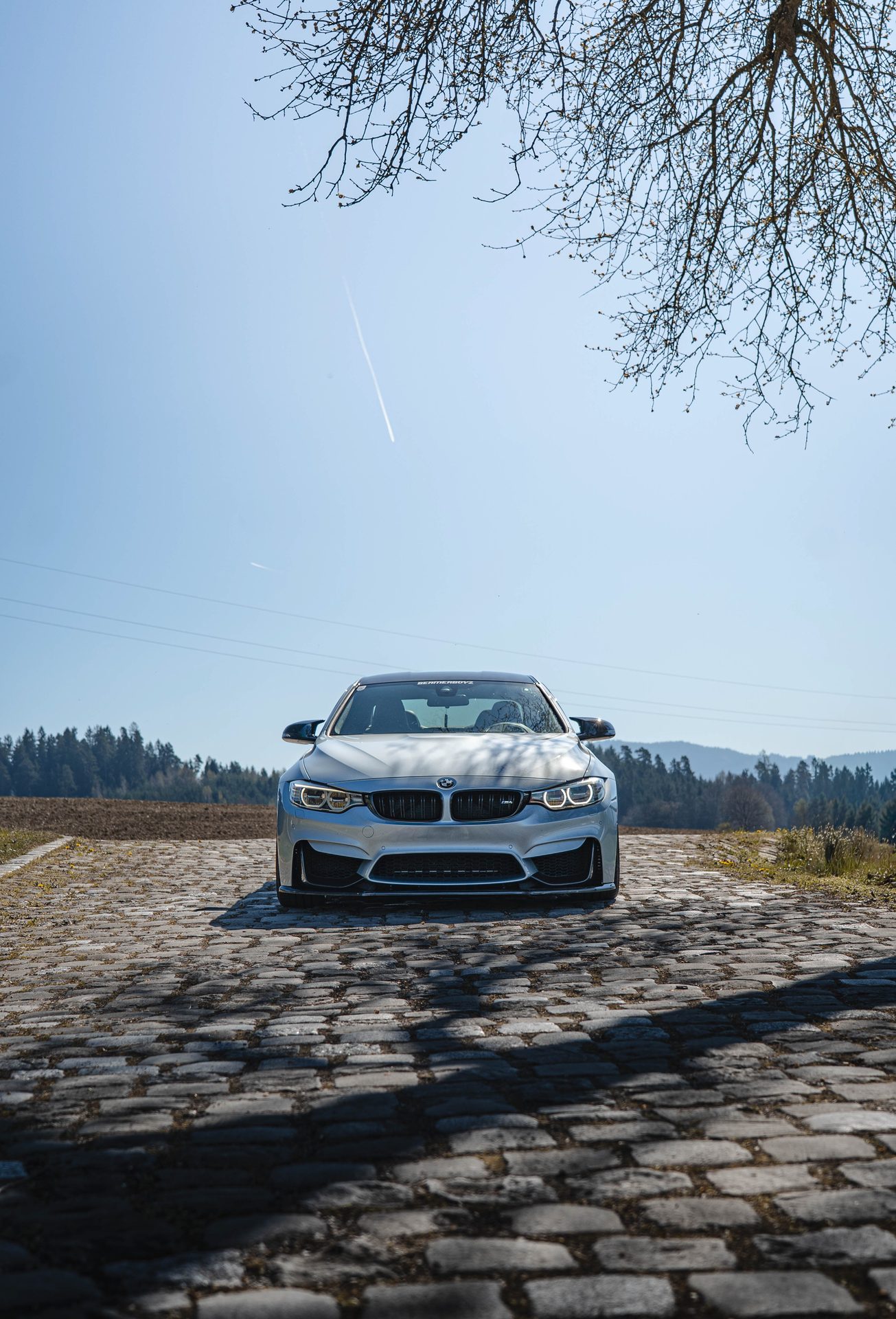 Autofotografie Kärnten — BMW M4 Coupé frontal auf Kopfsteinpflaster vor den Karawanken